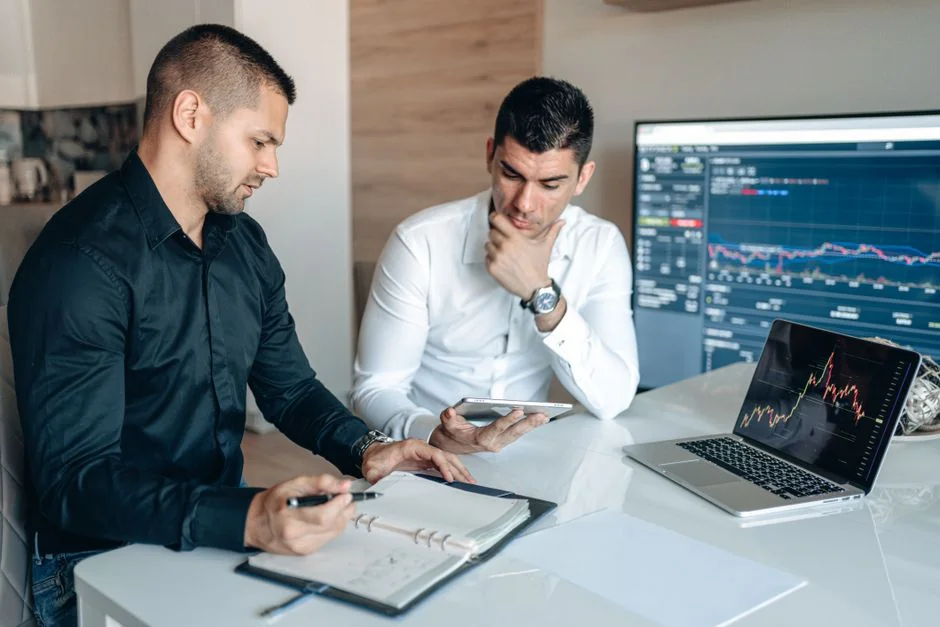Un espace de travail moderne où des mains analysent des données marketing sur un ordinateur portable et des documents papier.